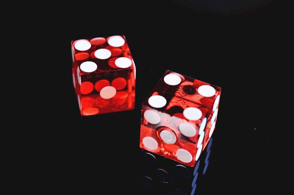 2 red dice representing luck and psychological bias of hindsight knowledge of an outcome
