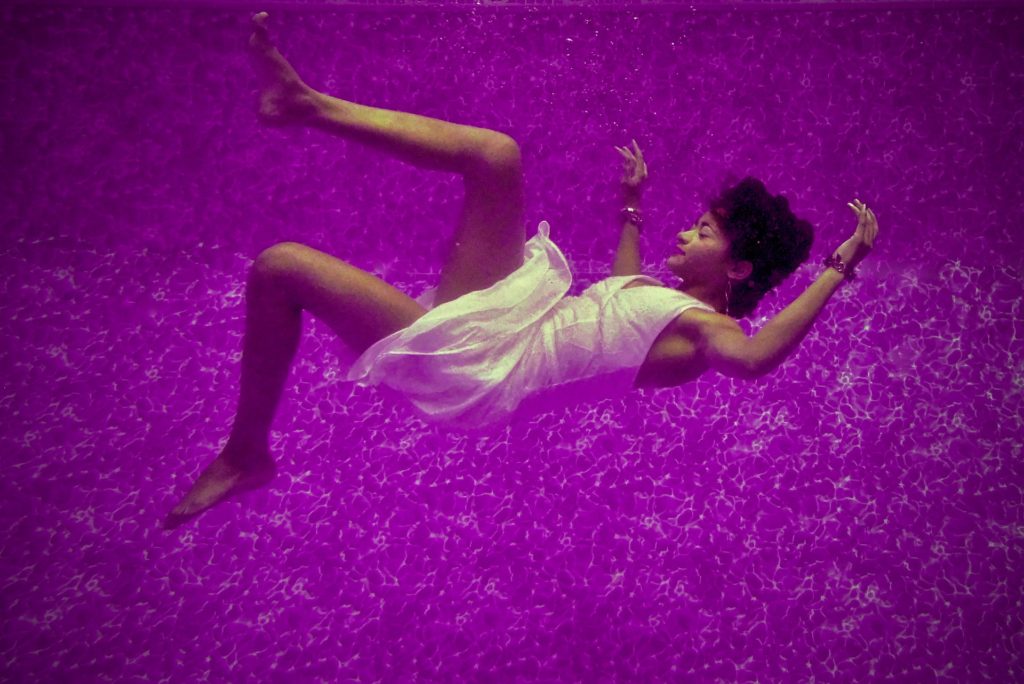 Woman falling into a deep purple sea while having a vivid lucid dream