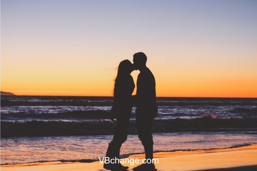 Romantic beautiful couple kissing and sharing their love for each other in the sunset