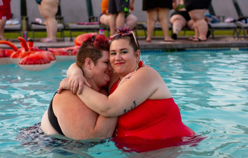 Two big beautiful women hugging and supporting each other happily at the pool wearing a bikini - 50 Best You Are Beautiful Quotes